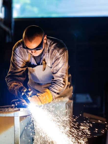 Worker cutting metal with plasma equipment on plant.